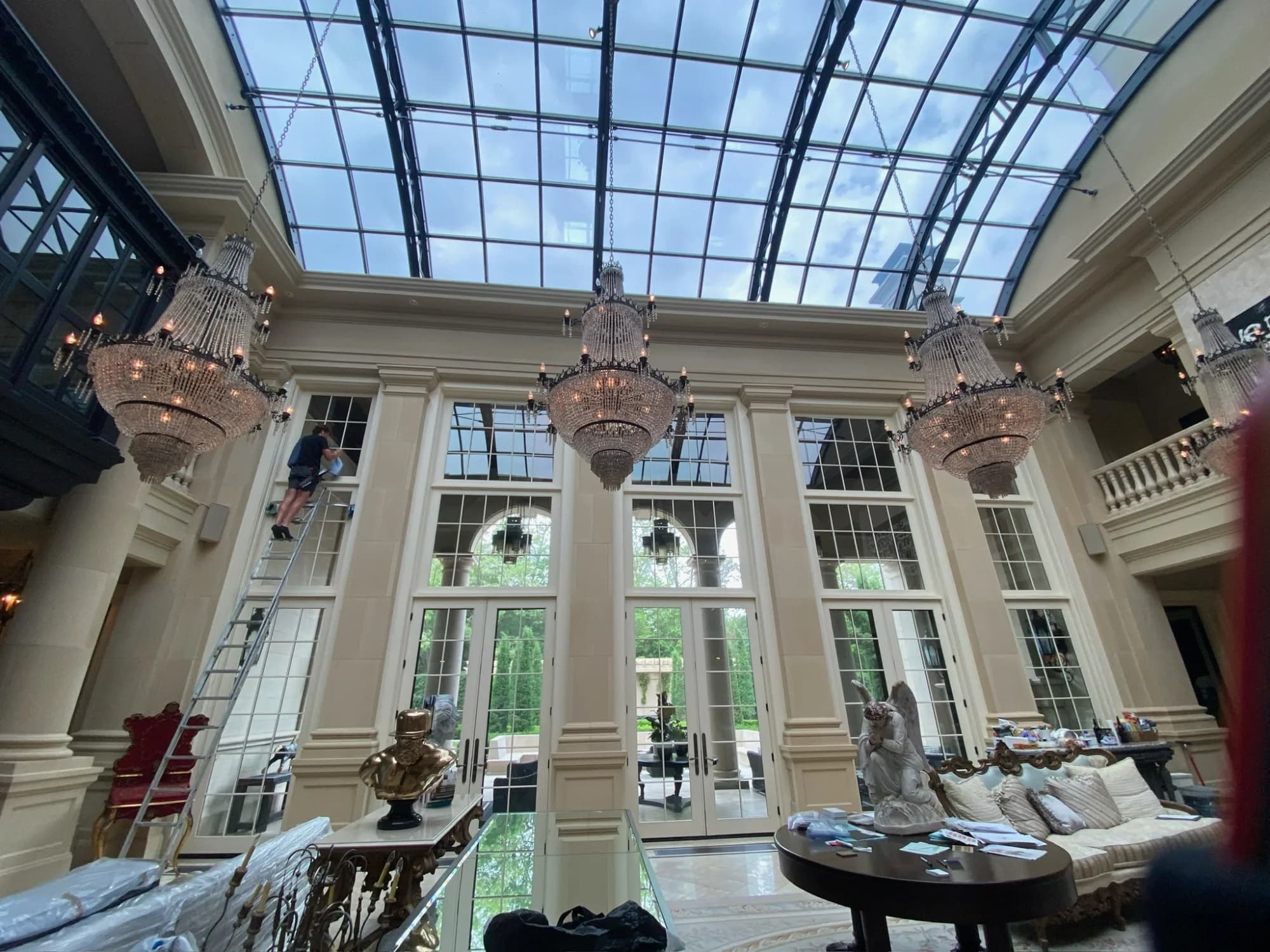 Grand glass-roofed atrium with chandeliers — commercial-scale interior glass cleaning