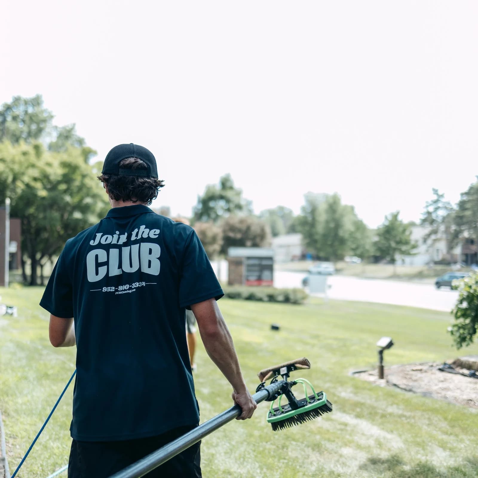 Two-person FCR crew walking a commercial jobsite with cleaning equipment