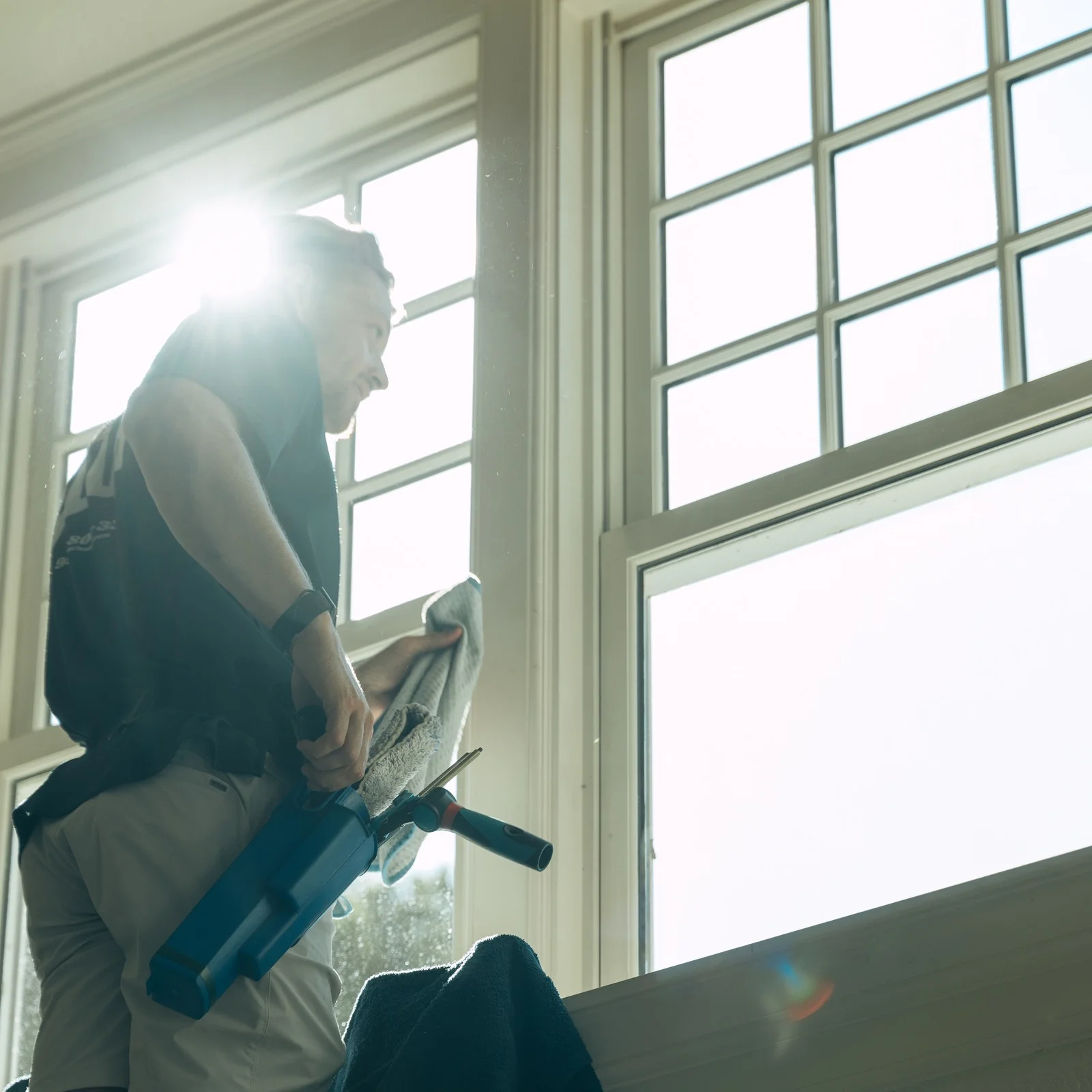 FCR technician cleaning an interior gable window inside a lake home