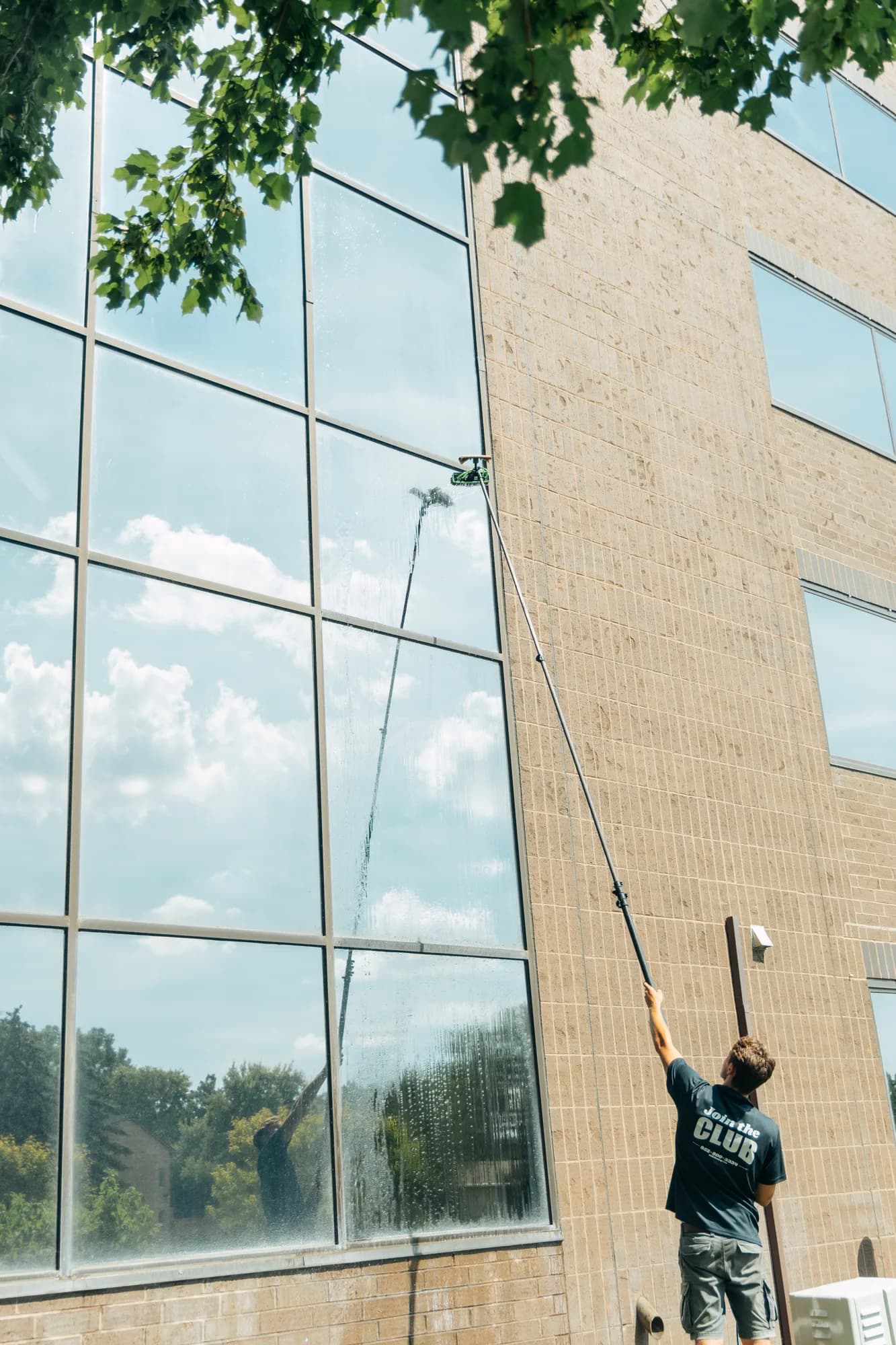 Reaching high commercial glass from the ground — no scaffolding needed