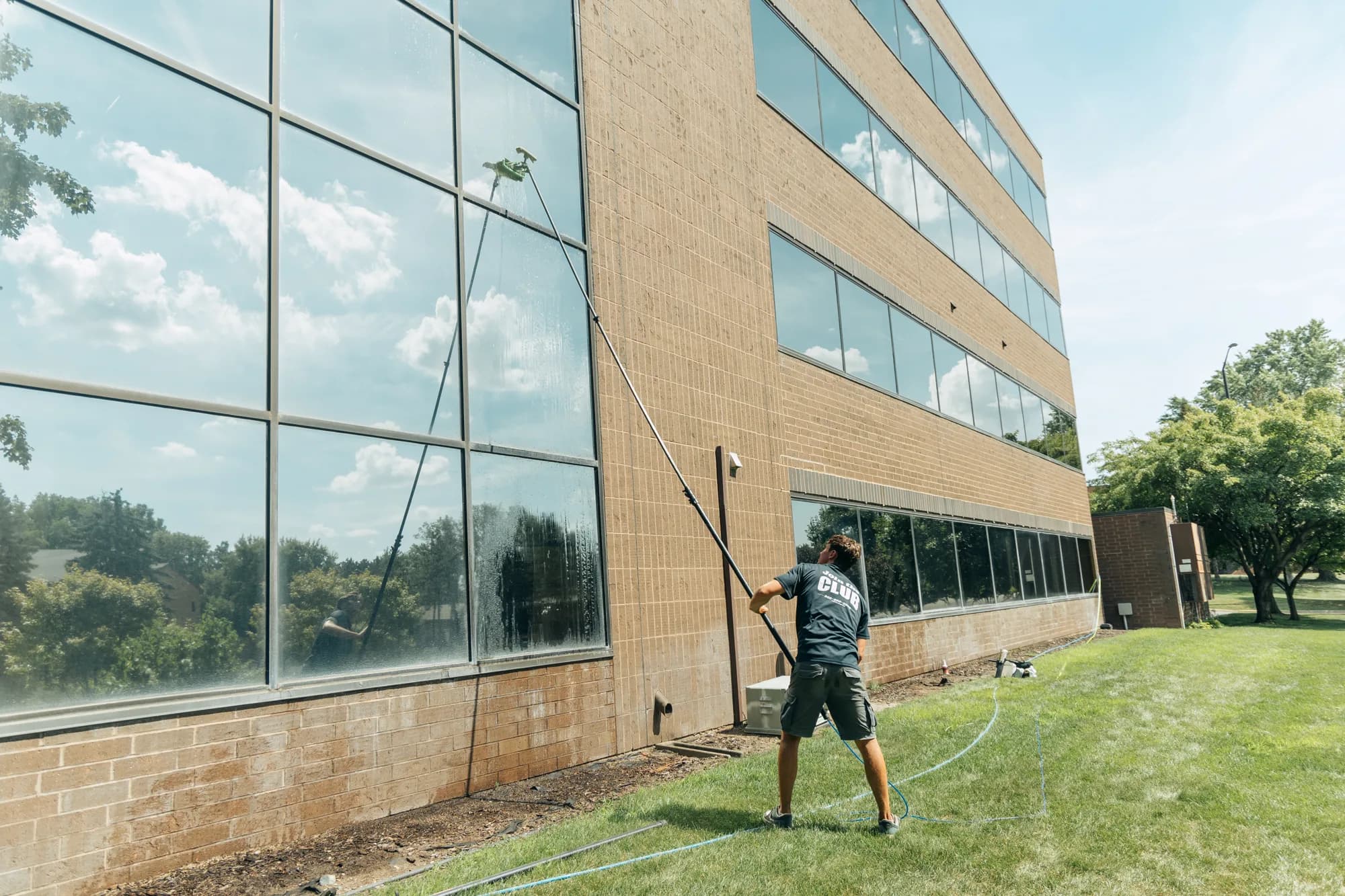 Water-fed pole work across a commercial building facade — Twin Cities MN