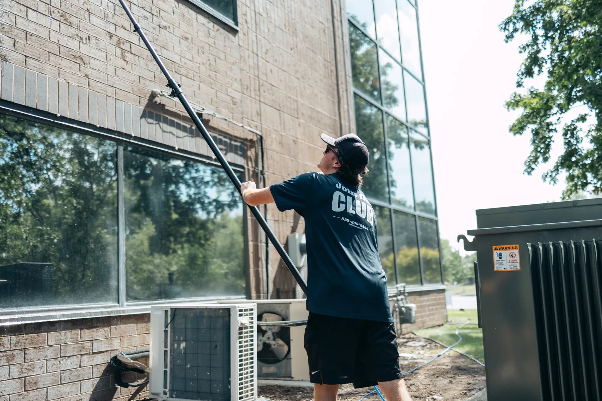 Scrubbing commercial windows on a stone facade — commercial window cleaning