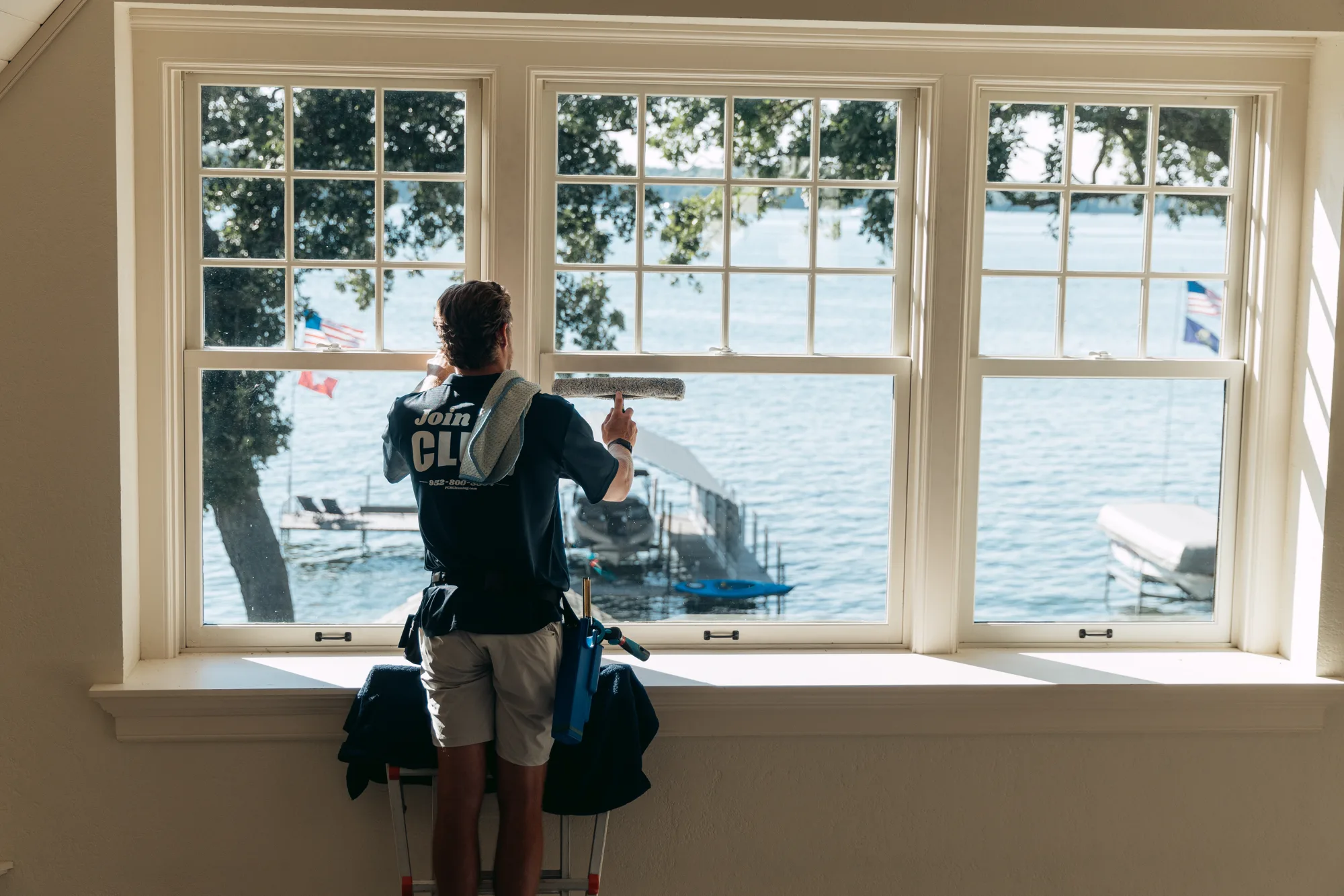 FCR technician finishing a wide lake-view bay window — professional window cleaning Twin Cities MN