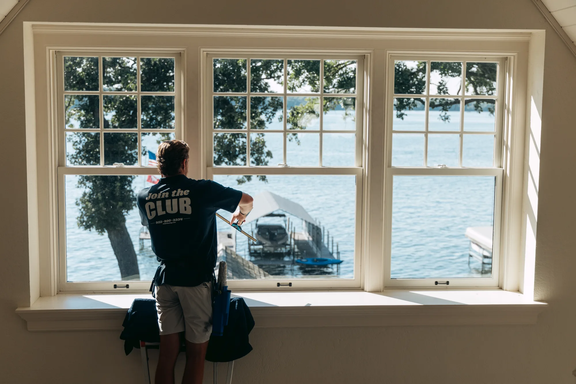 FCR technician detailing a lake-view picture window from the inside — interior window cleaning Twin Cities MN