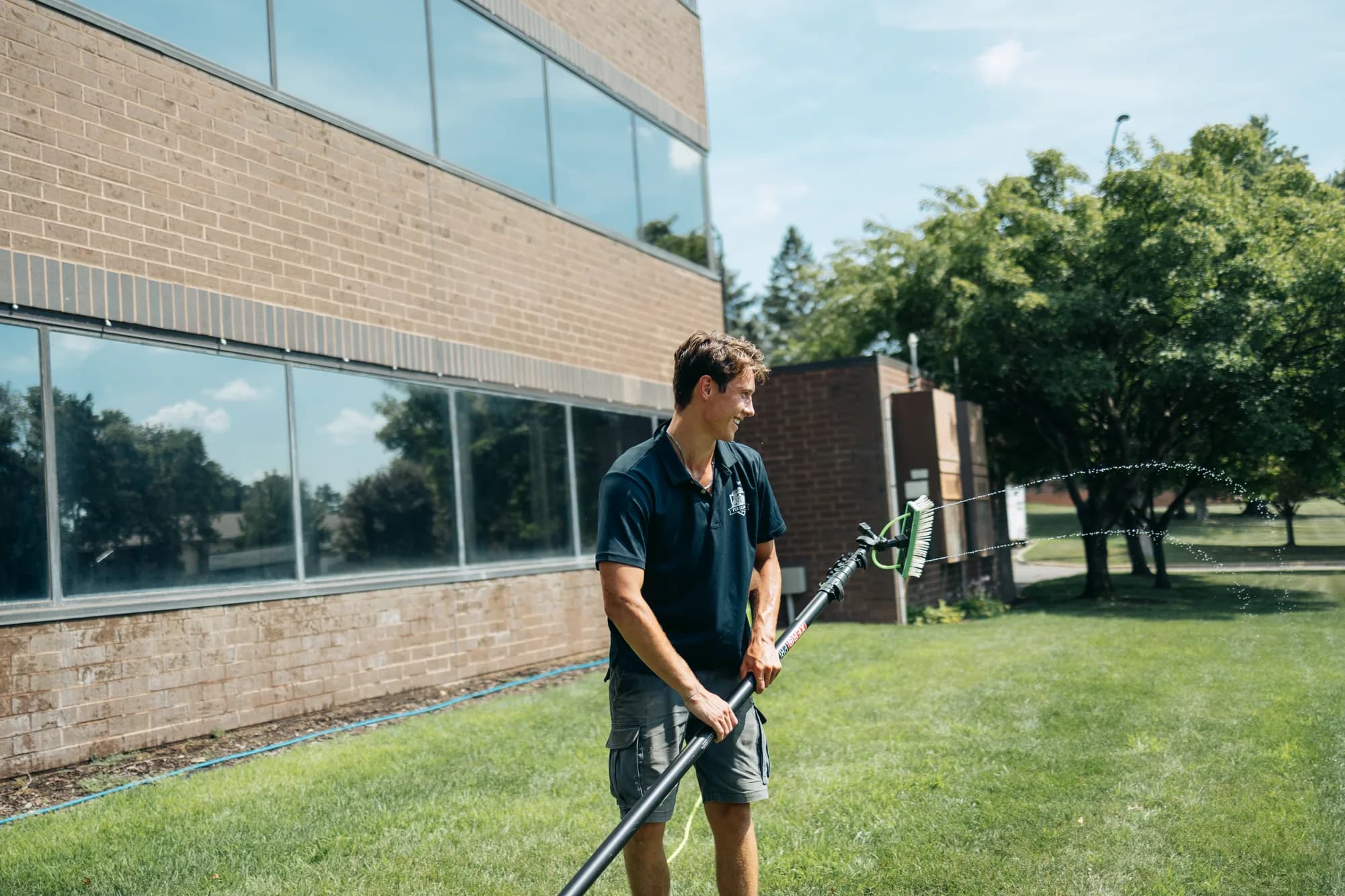 FCR technician with a water-fed pole on a commercial route — Twin Cities MN