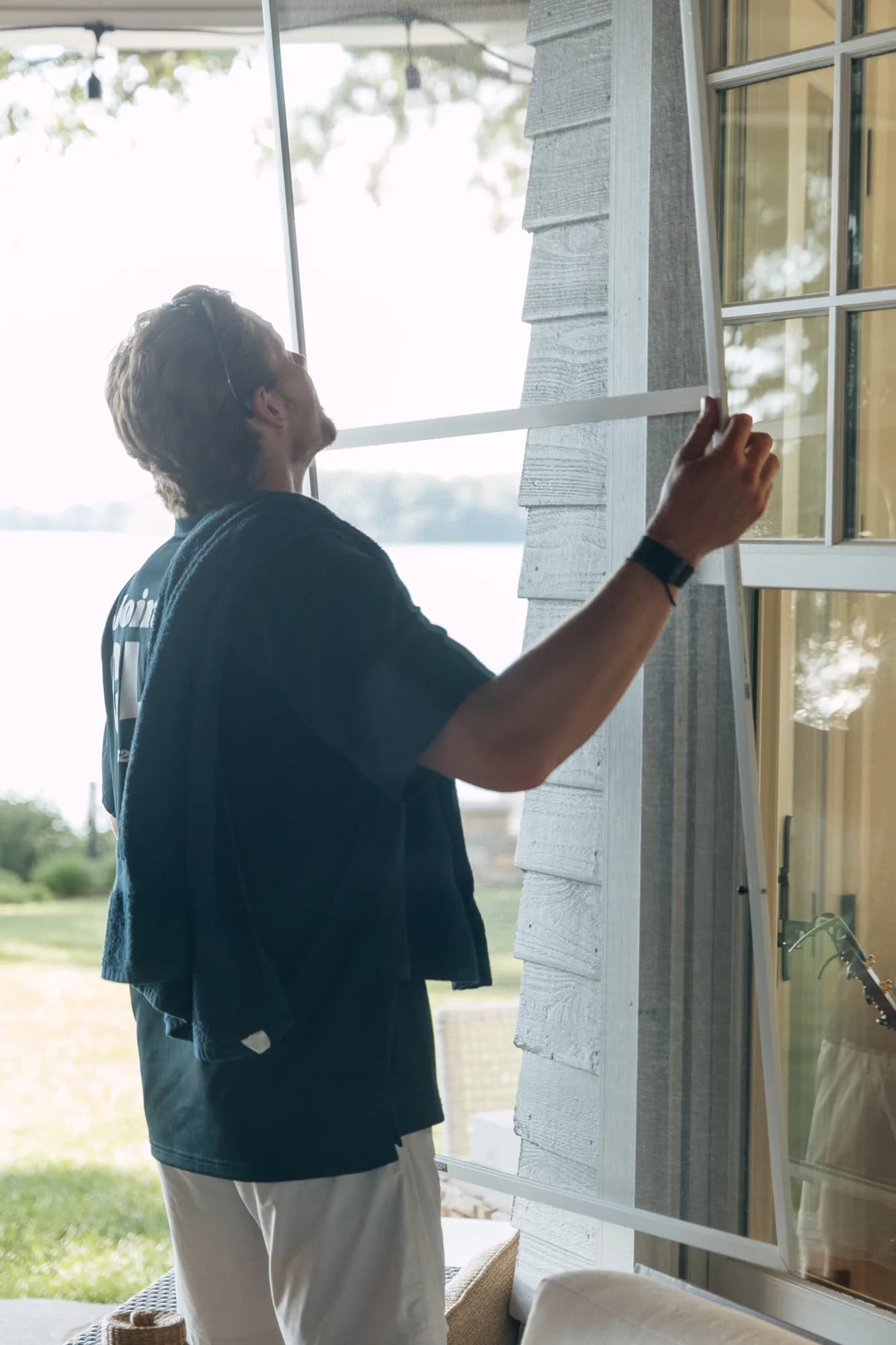 FCR technician wiping down a window screen in the afternoon light — screen cleaning Twin Cities MN