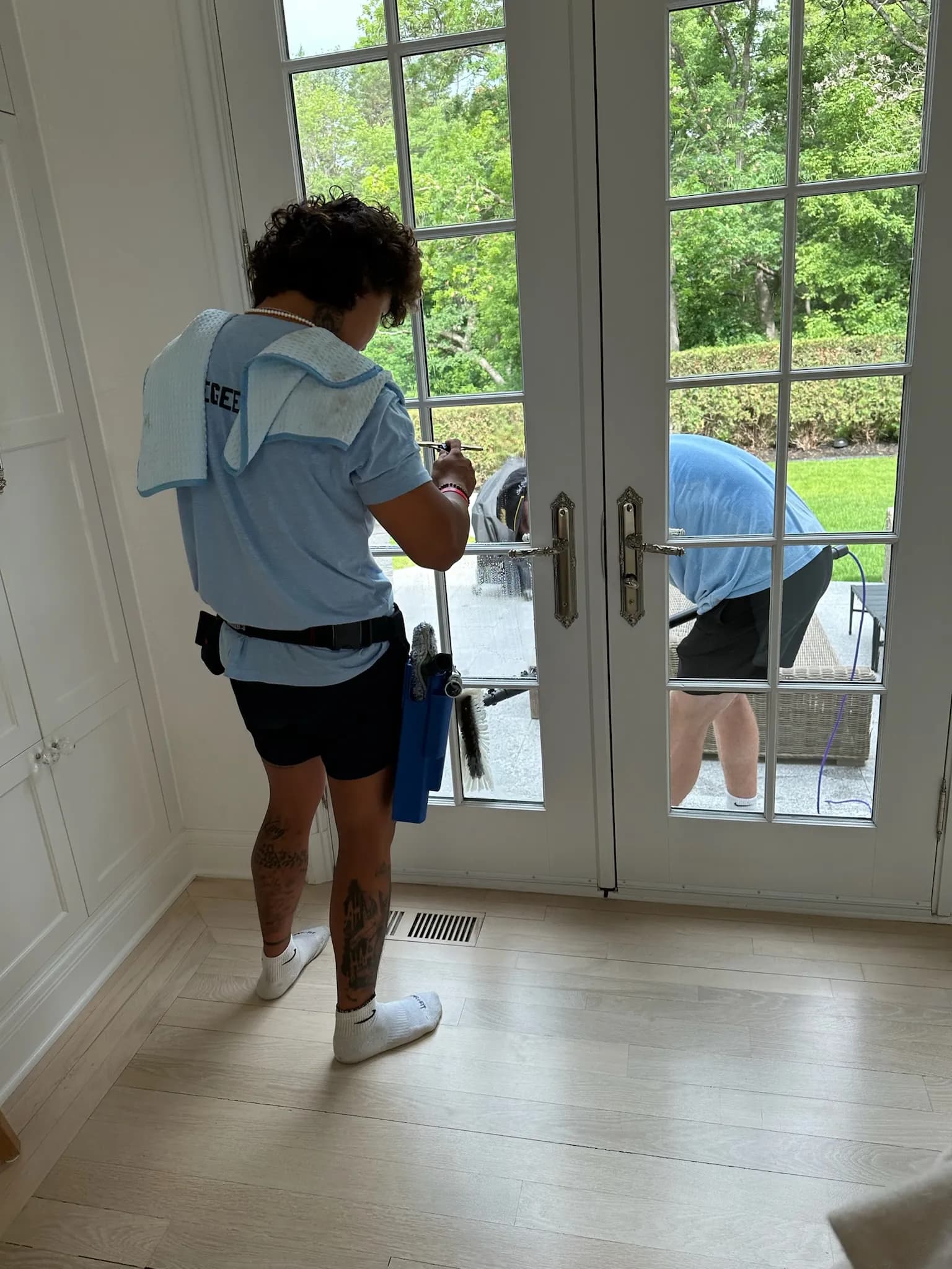 FCR Cleaning team cleaning French doors inside and outside at the same time — interior window cleaning Twin Cities MN
