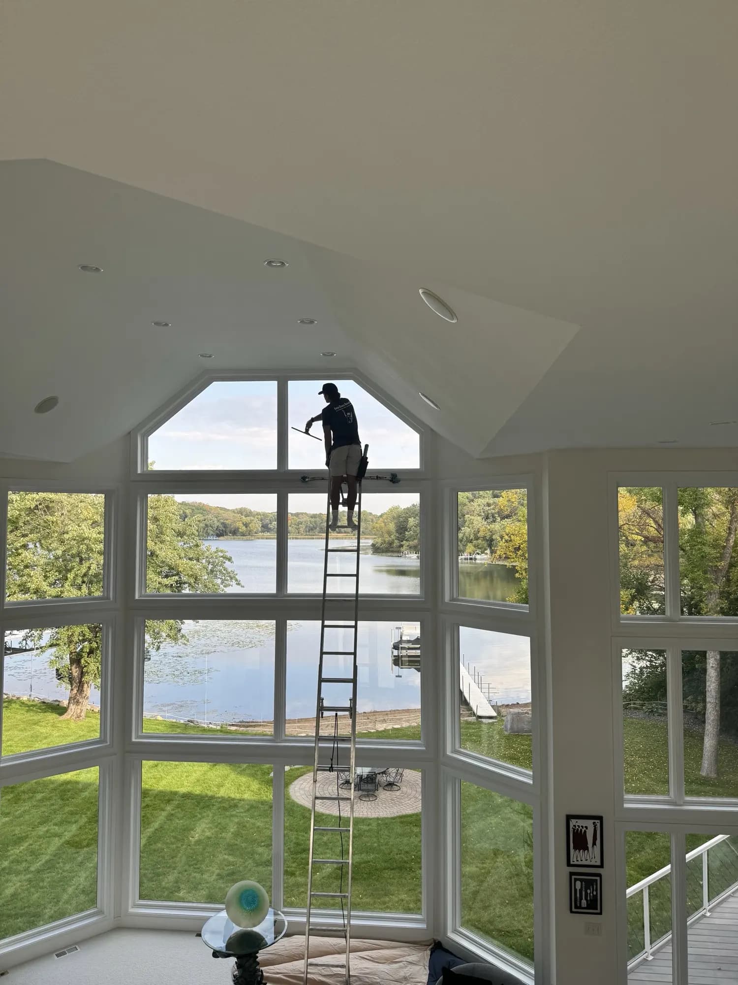FCR technician detailing a two-story lake-view window wall — streak-free result, Twin Cities MN
